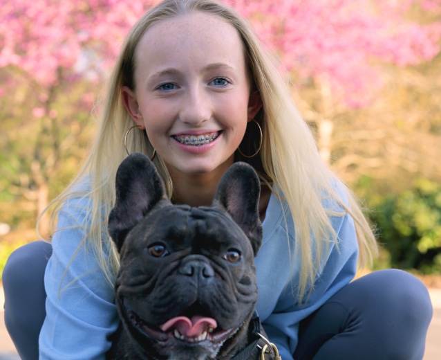 Girl with braces and her dog at Ragan Orthodontics in Dallas, TX
